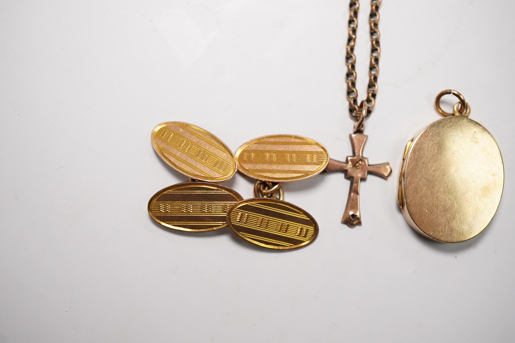 A pair of 9ct gold oval cufflinks, a 9ct chain with 9ct cross pendant and a 9ct gold oval locket, gross weight 14.3 grams. Condition - poor to fair